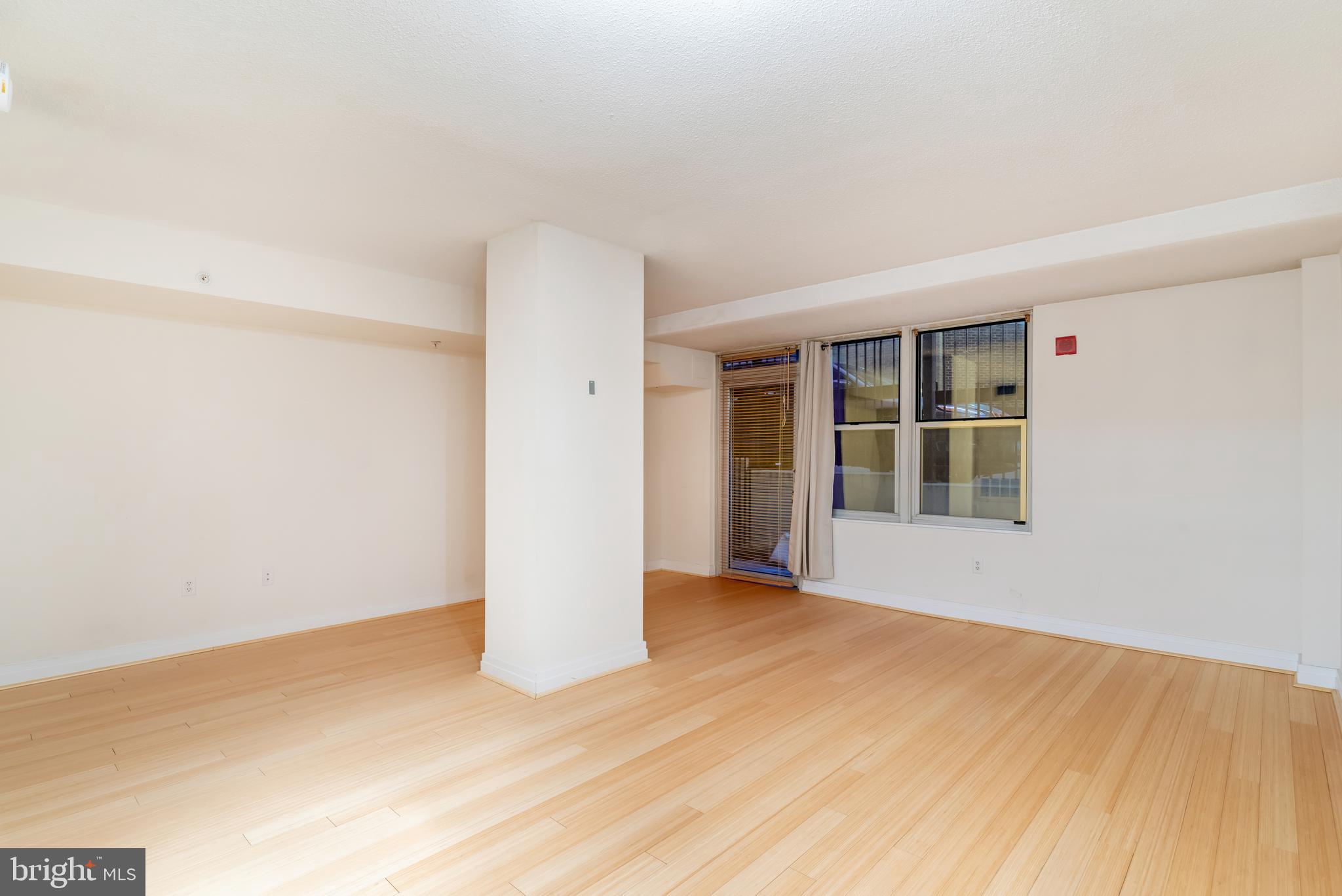 915 E Street Northwest, Unit 103 Washington, DC 20004 - Photo 21 of 43 a view of an empty room with wooden floor and a window