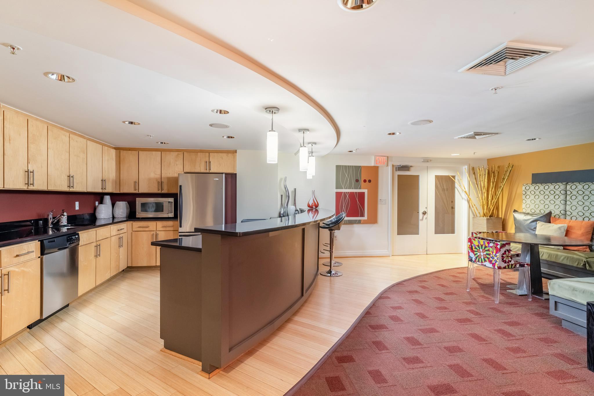 915 E Street Northwest, Unit 103 Washington, DC 20004 - Photo 38 of 43 a large kitchen with stainless steel appliances kitchen island granite countertop a large island in the center