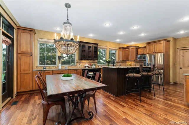 a kitchen with granite countertop kitchen island stainless steel appliances a sink and cabinets