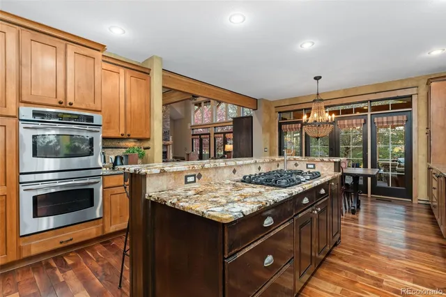 a large kitchen with kitchen island a sink and a large window