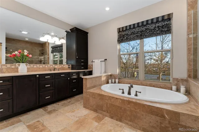 a spacious bathroom with a tub sink shower and mirror