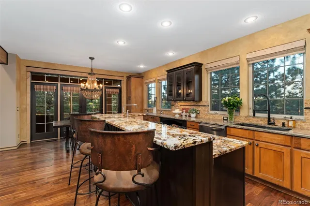 a dining room with wooden floor a chandelier a wooden table and chairs