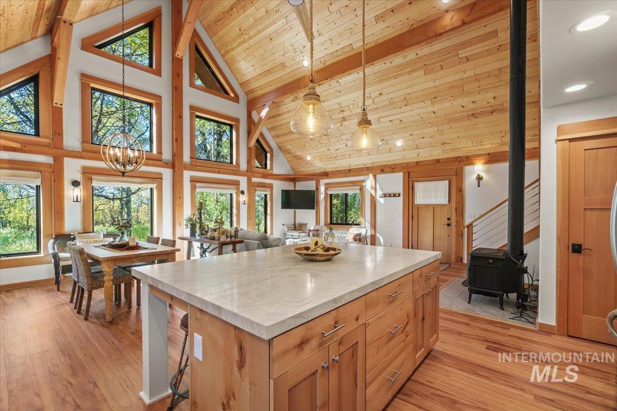 13982 Comfort Road McCall, ID 83638 - Photo 16 of 50 Kitchen with pendant lighting, high vaulted ceiling, a kitchen island, light countertops, and light wood-type flooring