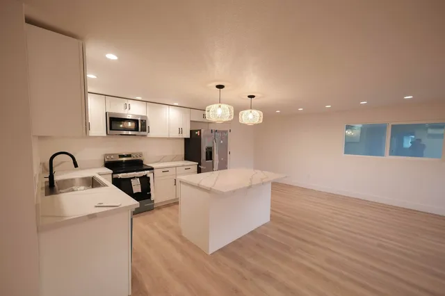 a view of kitchen with microwave a stove and wooden floor