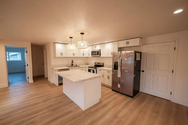 a kitchen with refrigerator cabinets and wooden floor
