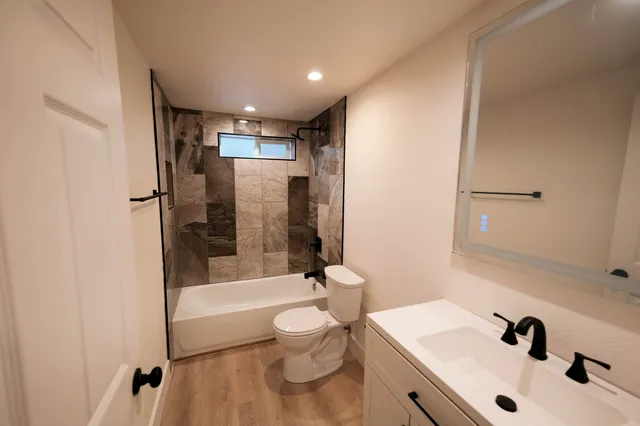 a bathroom with a sink a toilet and shower