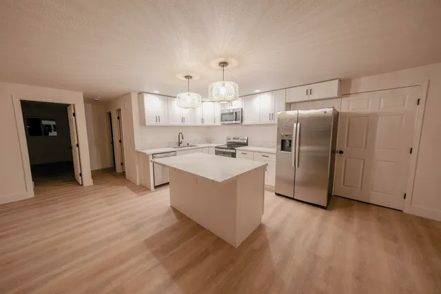 a kitchen with stainless steel appliances a refrigerator sink and cabinets
