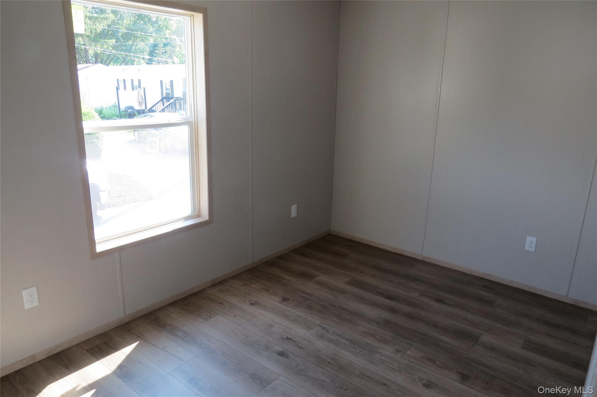 723 Beekman Road, Unit 48 Hopewell Junction, NY 12533 - Photo 6 of 14 a view of an empty room with wooden floor and a window