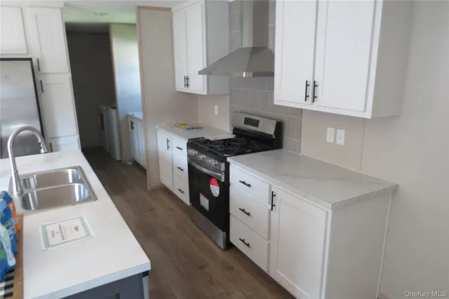 a kitchen with a sink a stove and cabinets