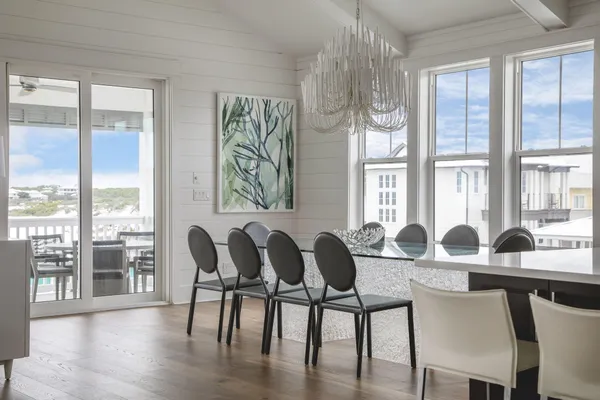 a kitchen with stainless steel appliances granite countertop a stove a sink dishwasher a dining table and chairs with wooden floor