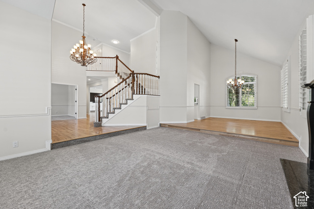 10664 Trail Ridge Circle Sandy, UT 84092 - Photo 8 of 113 Vaulted ceilings with decorative chandeliers, a split-level design, and a grand staircase with wood railing