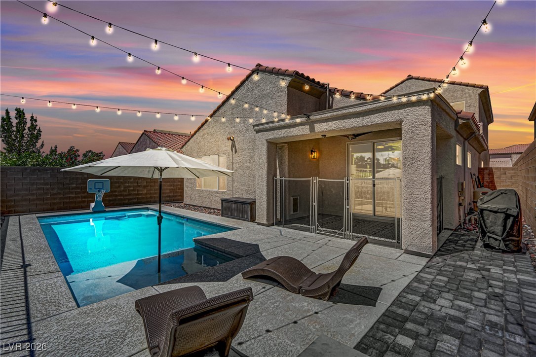 2835 Strathallan Avenue Henderson, NV 89044 - Photo 1 of 64 Pool at dusk featuring a patio, a fenced backyard, and a grill