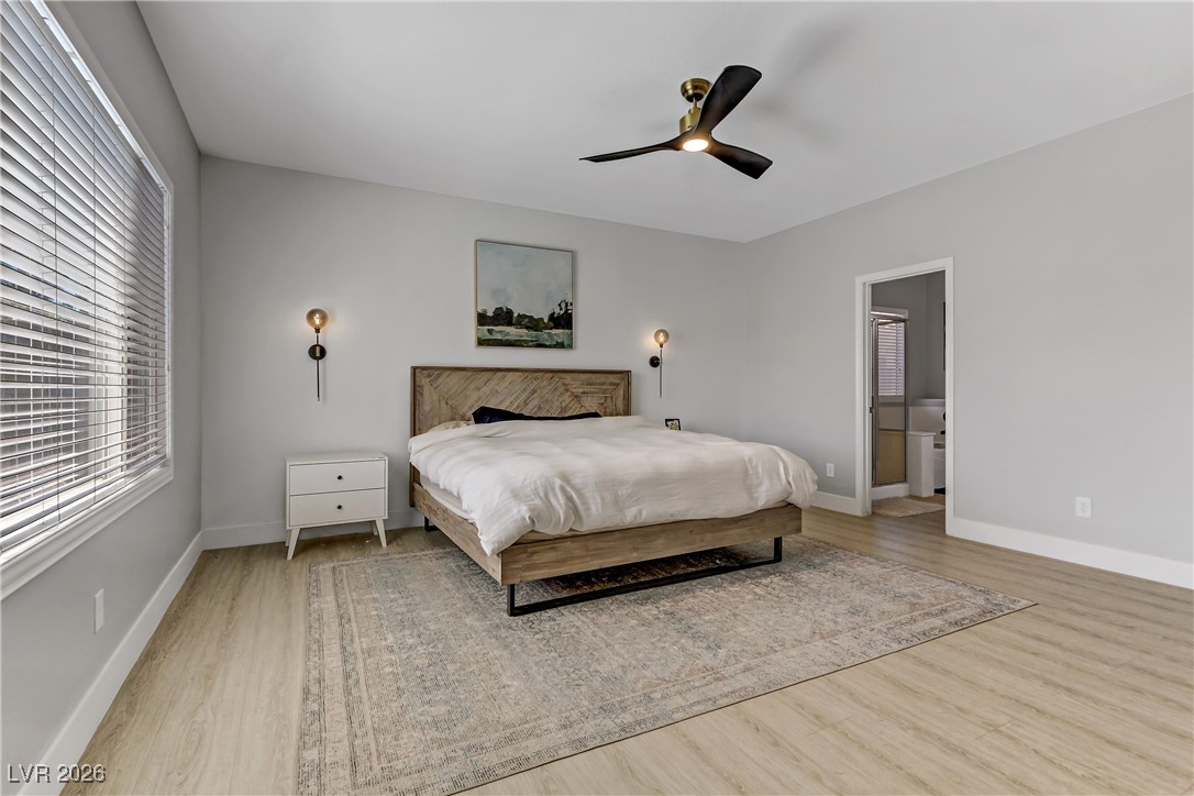 2835 Strathallan Avenue Henderson, NV 89044 - Photo 18 of 64 Bedroom with light wood-style floors, ceiling fan, and connected bathroom