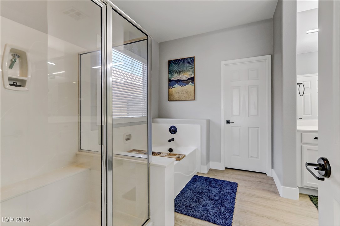 2835 Strathallan Avenue Henderson, NV 89044 - Photo 21 of 64 Full bathroom featuring a shower stall, a garden tub, light wood-style flooring, and vanity