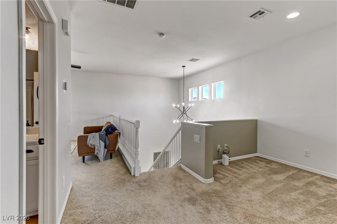 2835 Strathallan Avenue Henderson, NV 89044 - Photo 32 of 64 Corridor with an upstairs landing, light colored carpet, and a chandelier