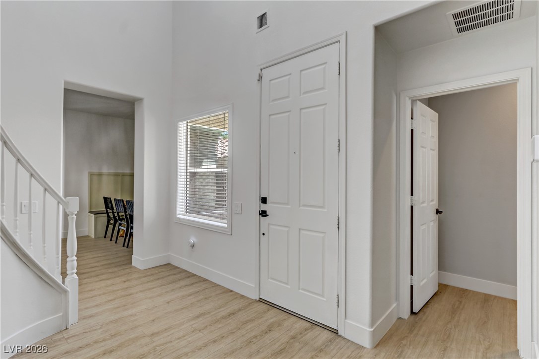 2835 Strathallan Avenue Henderson, NV 89044 - Photo 5 of 64 Foyer entrance featuring light wood-type flooring, stairs, and a towering ceiling