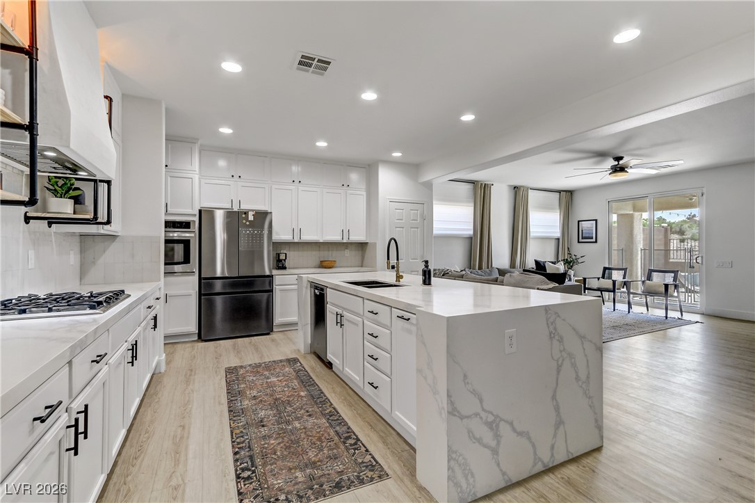 2835 Strathallan Avenue Henderson, NV 89044 - Photo 6 of 64 Kitchen featuring white cabinets, appliances with stainless steel finishes, light wood-style flooring, a ceiling fan, and recessed lighting
