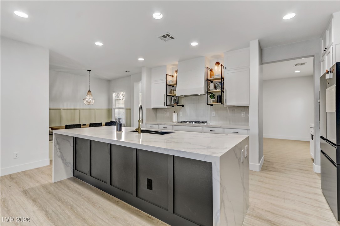 2835 Strathallan Avenue Henderson, NV 89044 - Photo 7 of 64 Kitchen with white cabinetry, light stone countertops, decorative light fixtures, and recessed lighting