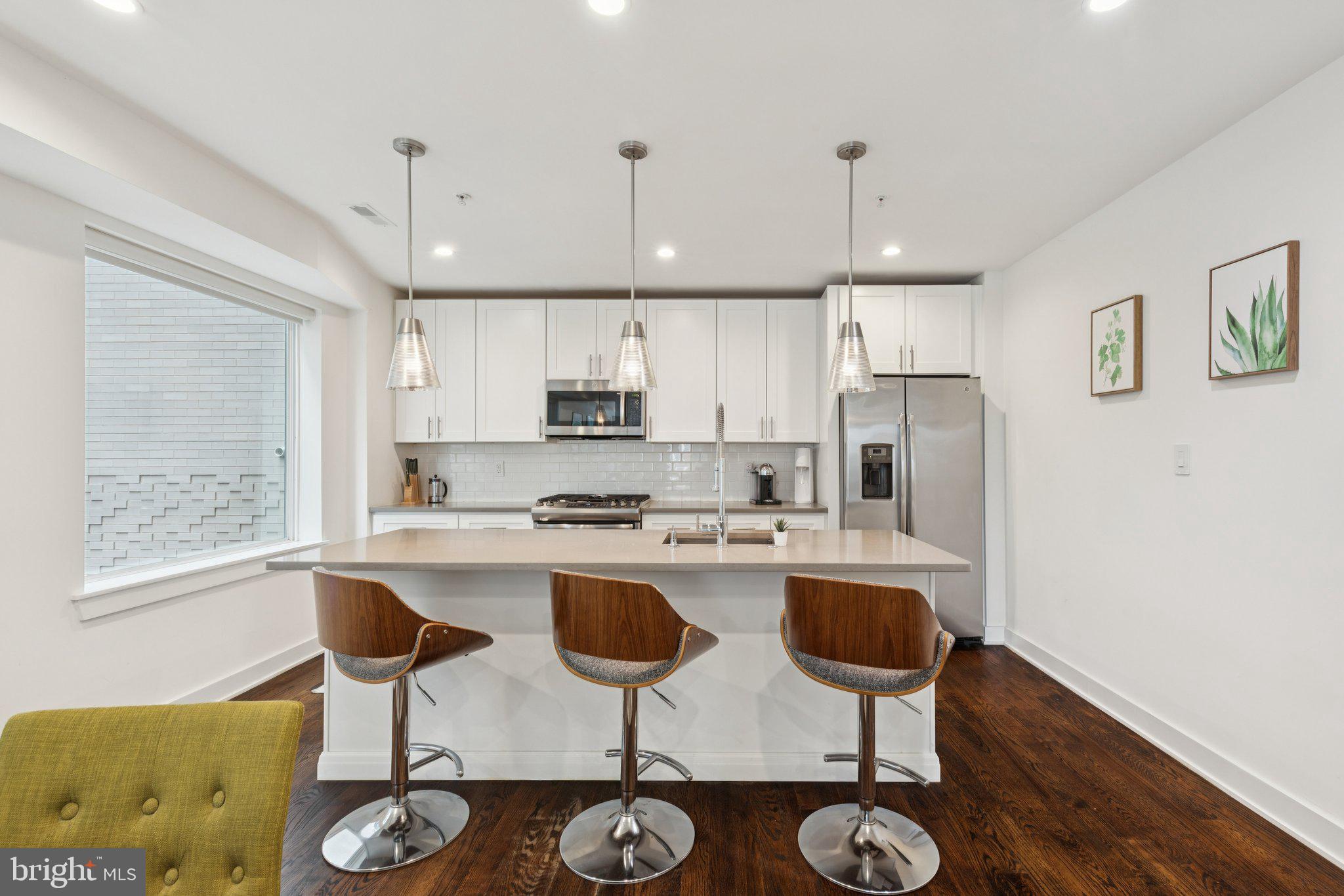 1022 South 2nd Street, Unit 2 Philadelphia, PA 19147 - Photo 2 of 46 a kitchen with stainless steel appliances granite countertop a stove a sink a refrigerator and chairs with wooden floor
