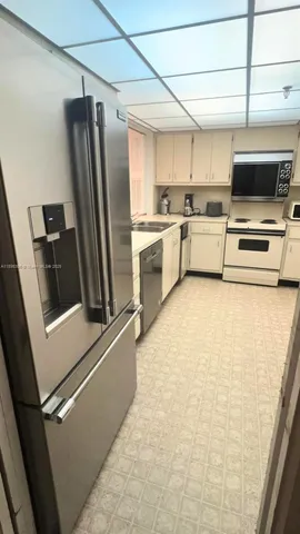 a kitchen with stainless steel appliances a refrigerator sink and microwave
