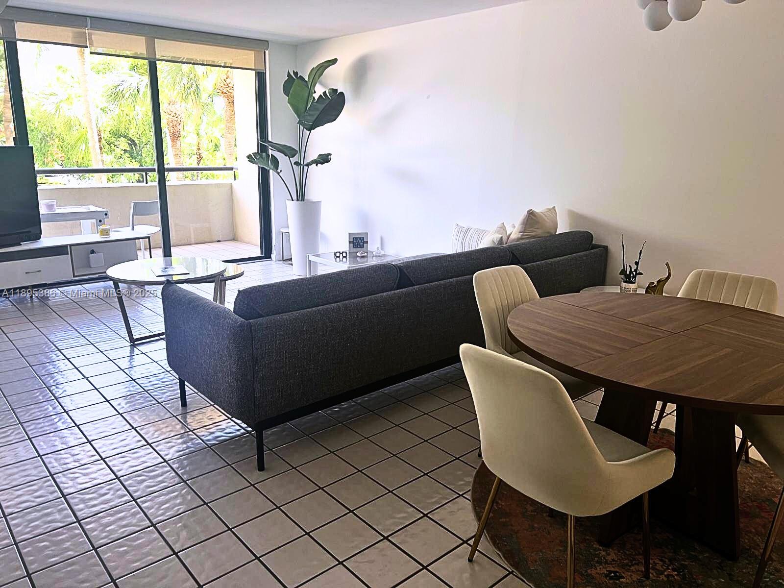 170 Ocean Ln Drive, Unit 311 Key Biscayne, FL 33149 - Photo 9 of 32 a living room with couches a table and a potted plant with wooden floor