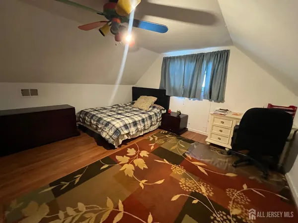 a bedroom with two beds and a lamp on dresser