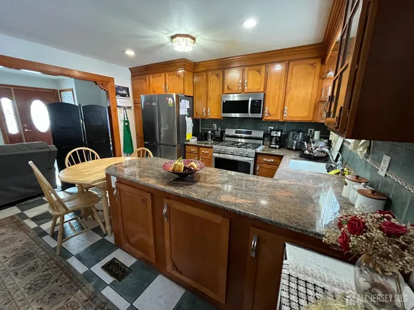 a kitchen with stainless steel appliances granite countertop sink stove and refrigerator
