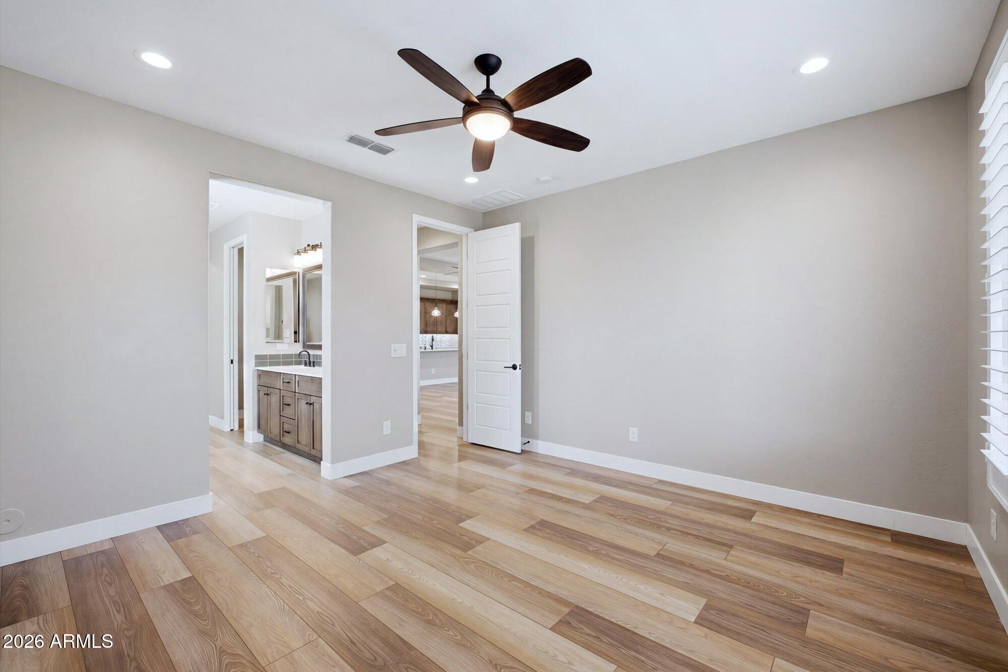 16849 West Merrell Street Goodyear, AZ 85395 - Photo 17 of 35 an empty room with wooden floor and ceiling fan