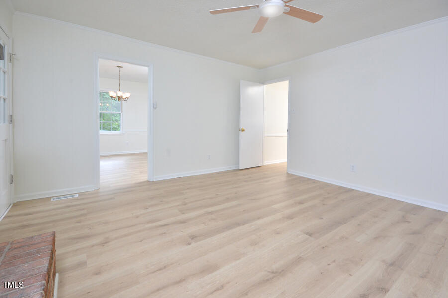 5825 Scalybark Road Durham, NC 27712 - Photo 11 of 44 an empty room with a ceiling fan and wooden floor