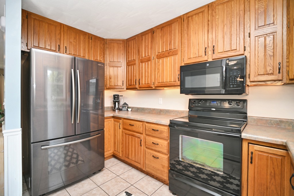 501 Carriage Hills Road Normal, IL 61761 - Photo 12 of 77 a kitchen with granite countertop a refrigerator stove and microwave