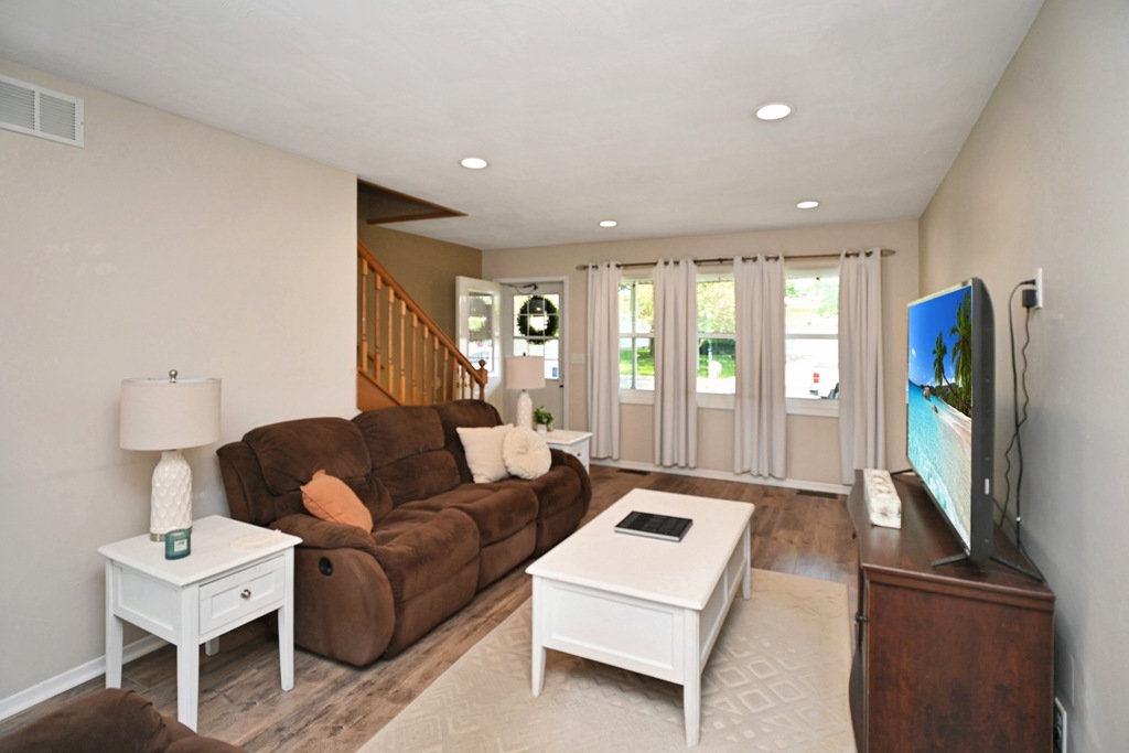 501 Carriage Hills Road Normal, IL 61761 - Photo 26 of 77 a living room with furniture a flat screen tv and a large window