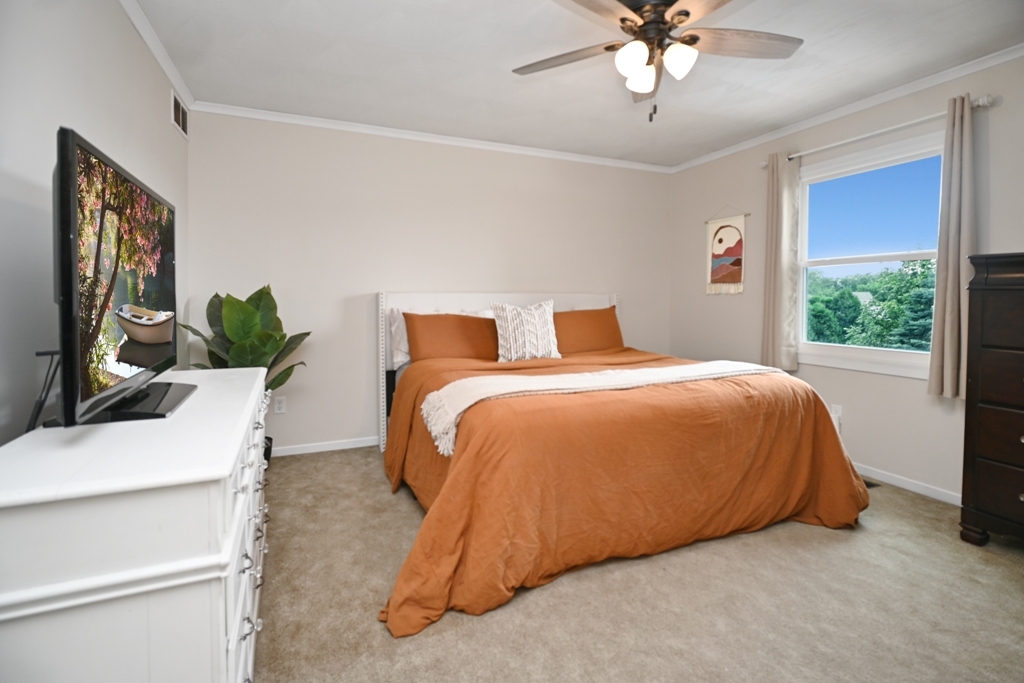 501 Carriage Hills Road Normal, IL 61761 - Photo 33 of 77 a bedroom with a large bed and a chandelier