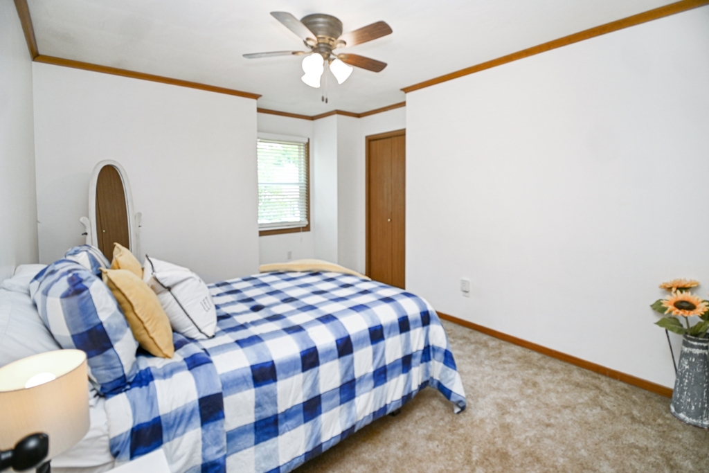 501 Carriage Hills Road Normal, IL 61761 - Photo 45 of 77 a bedroom with a bed and a chandelier