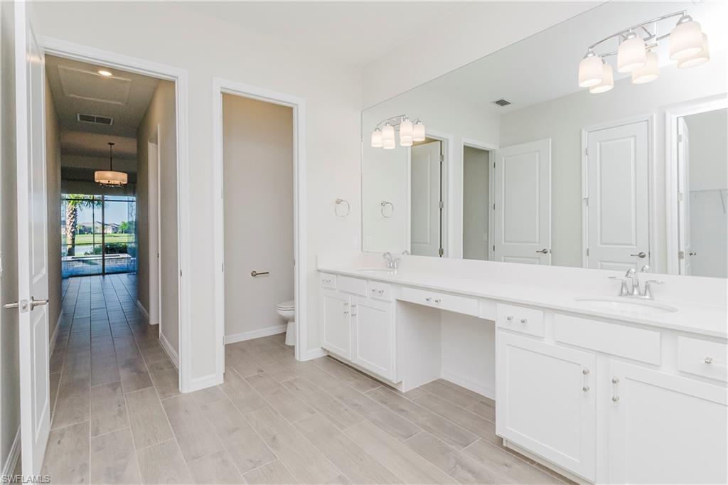 5423 Ternberry Road Ave Maria, FL 34142 - Photo 13 of 50 a bathroom with a double vanity sink and mirror