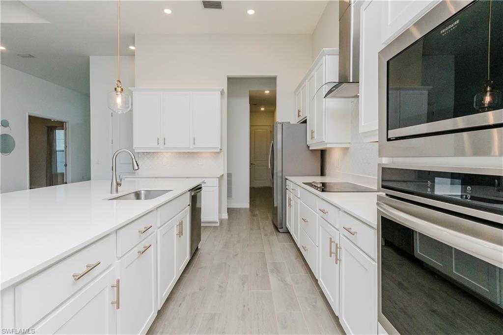 5423 Ternberry Road Ave Maria, FL 34142 - Photo 9 of 50 a large kitchen with a stove and a sink