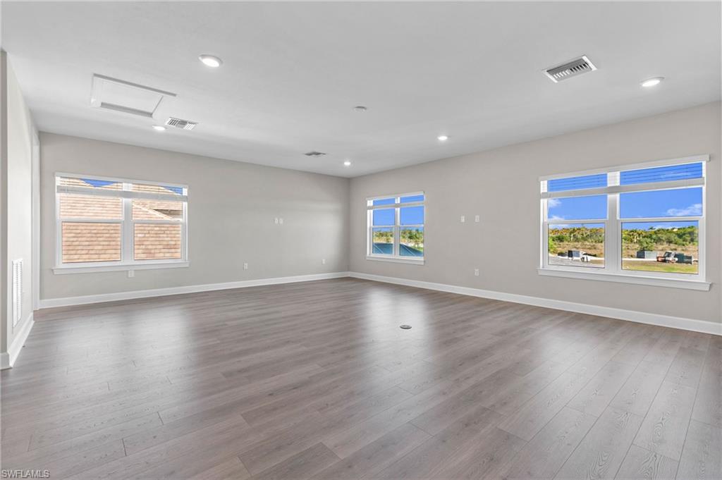 15564 Montello Lane Naples, FL 34114 - Photo 21 of 49 an empty room with window and wooden floor