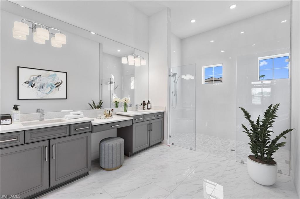 15564 Montello Lane Naples, FL 34114 - Photo 30 of 49 a spacious bathroom with a double vanity sink a mirror and a
