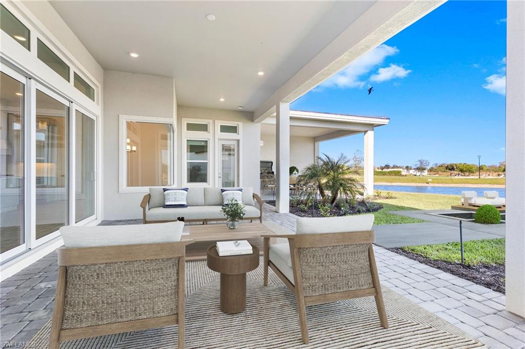 15564 Montello Lane Naples, FL 34114 - Photo 43 of 49 a living room with patio furniture and a floor to ceiling window