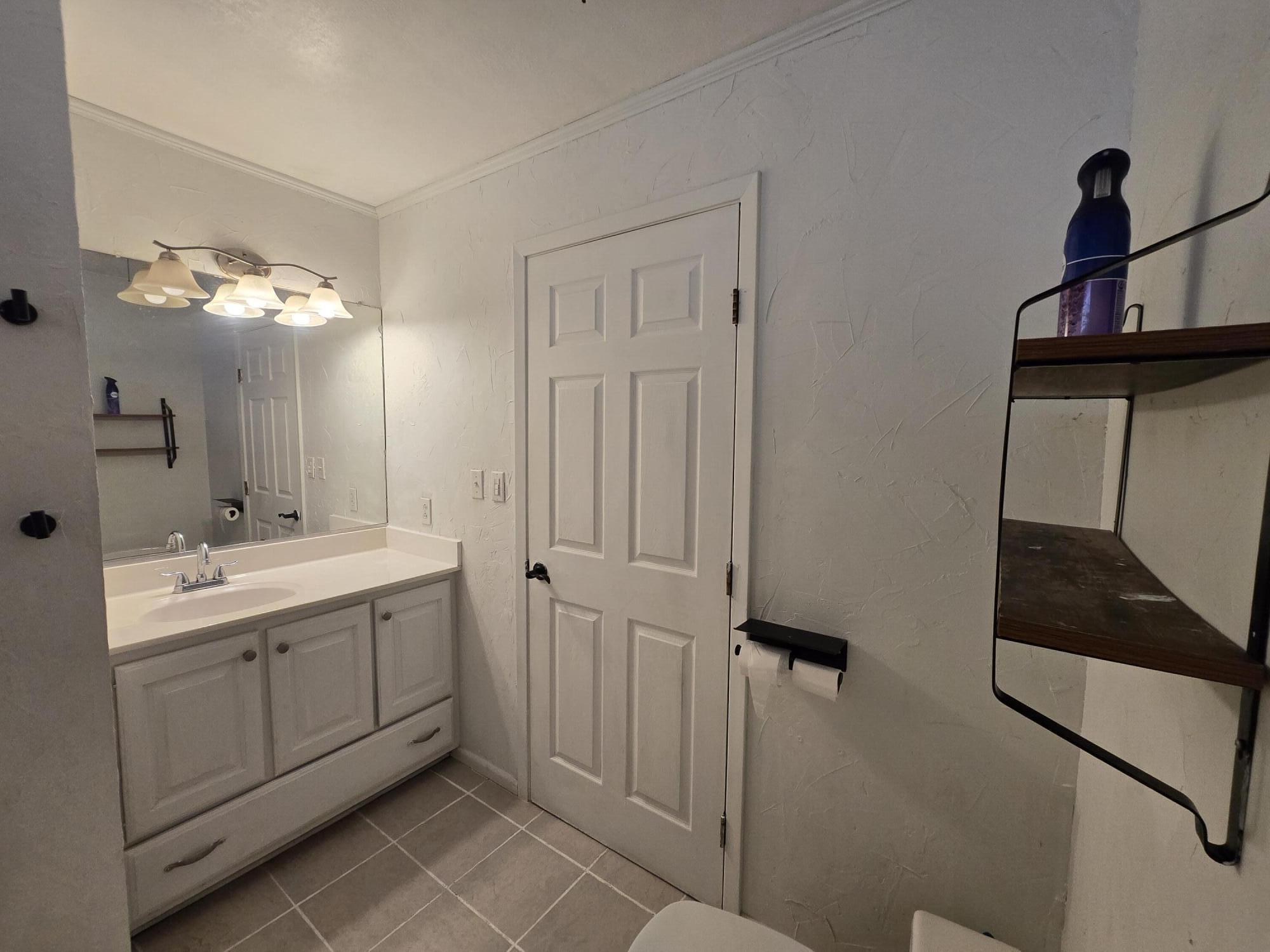 506 North 19th Street Lamesa, TX 79331 - Photo 14 of 29 a bathroom with a double vanity sink a toilet and a mirror