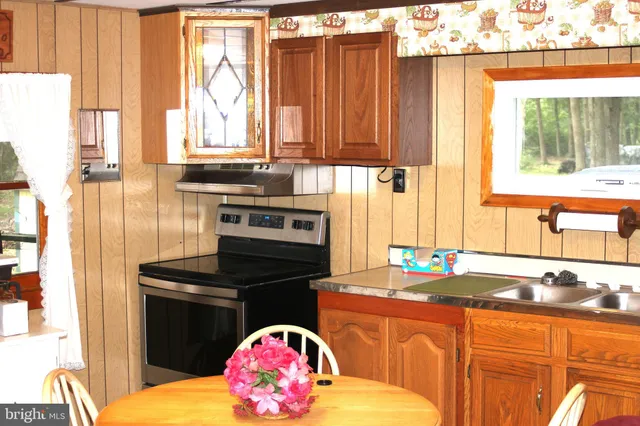 a kitchen with granite countertop a stove a sink and a window