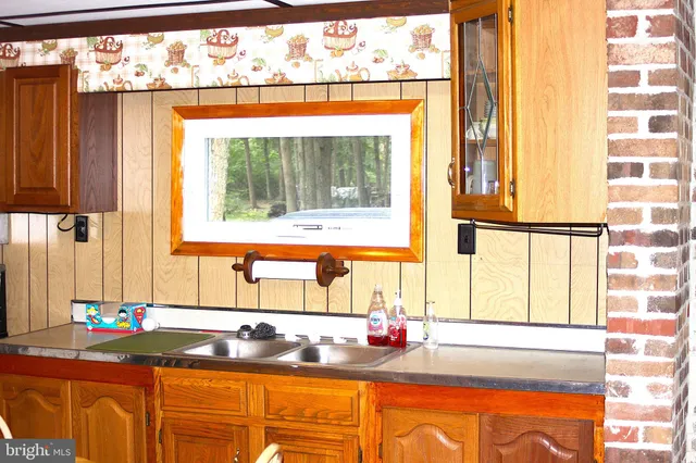 a kitchen with a window sink and cabinets