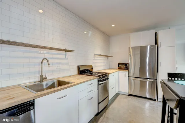 a kitchen with a sink a refrigerator and cabinets