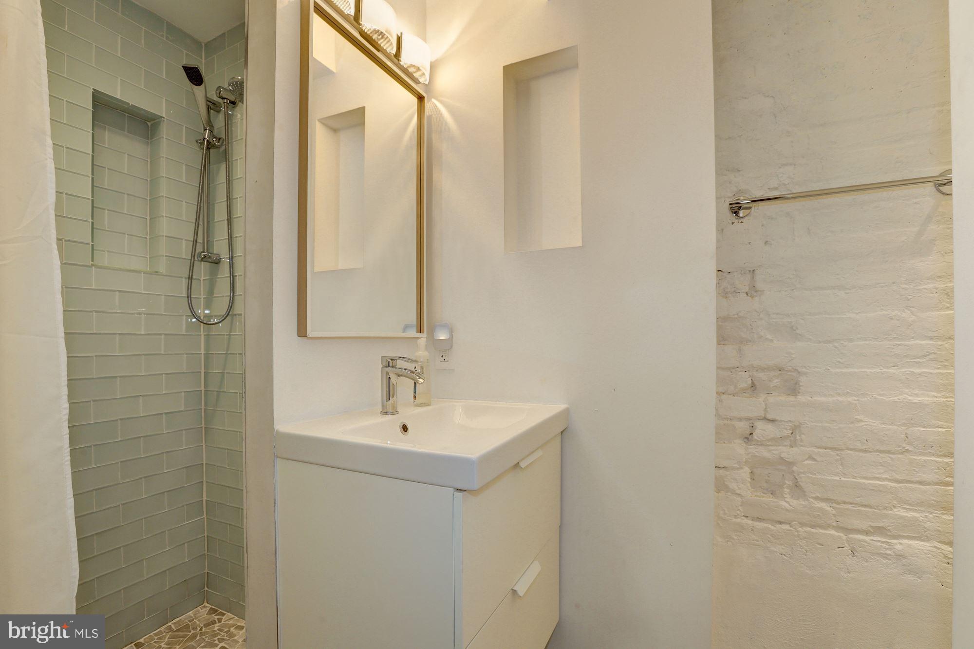 400 U Street Northwest, Unit LL Washington, DC 20001 - Photo 6 of 10 a bathroom with a sink a shower and a mirror