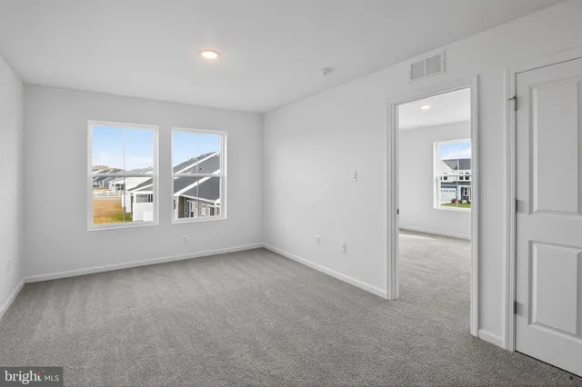 an empty room with windows and closet