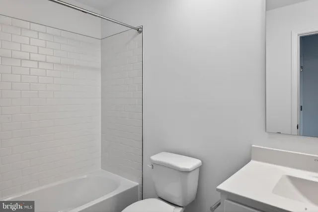 a white toilet sitting next to a bath tub