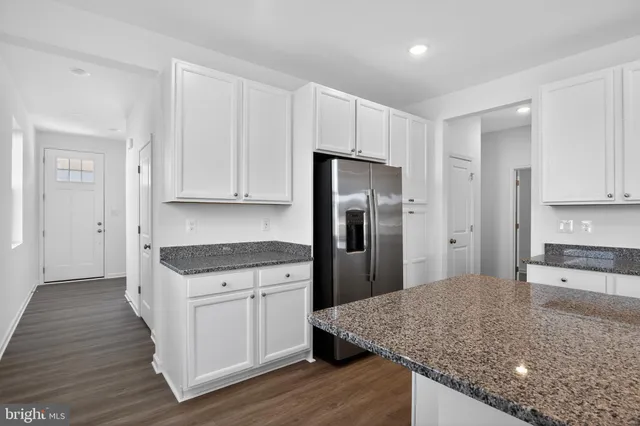 a kitchen with stainless steel appliances granite countertop a stove a refrigerator and a sink