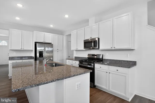 a kitchen with sink a microwave and cabinets