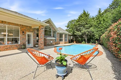 a view of swimming pool with lounge chair and dinning table under an umbrella