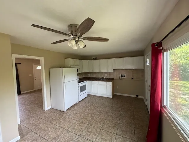 a view of a kitchen with a sink refrigerator and window