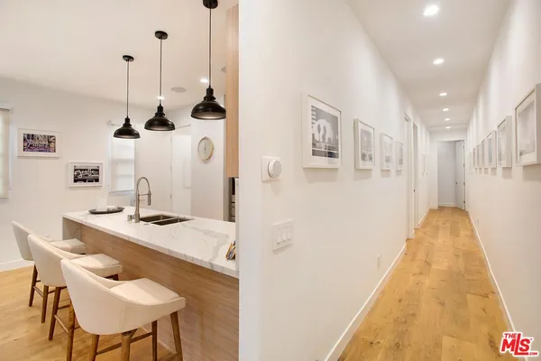 a dining room with stainless steel appliances kitchen island a table chairs and a refrigerator